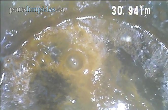 Ce puits souffre d'infiltrations dans sa partie supérieure, le biofilm bactérien coule sur la paroi jusqu'à la surface de l'eau. Cet exemple est un cas extrême de contamination. 