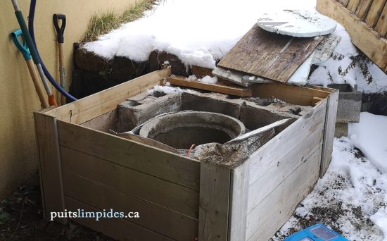 Puits de surface avec un couvercle de fortune non conforme et non étanche en bois